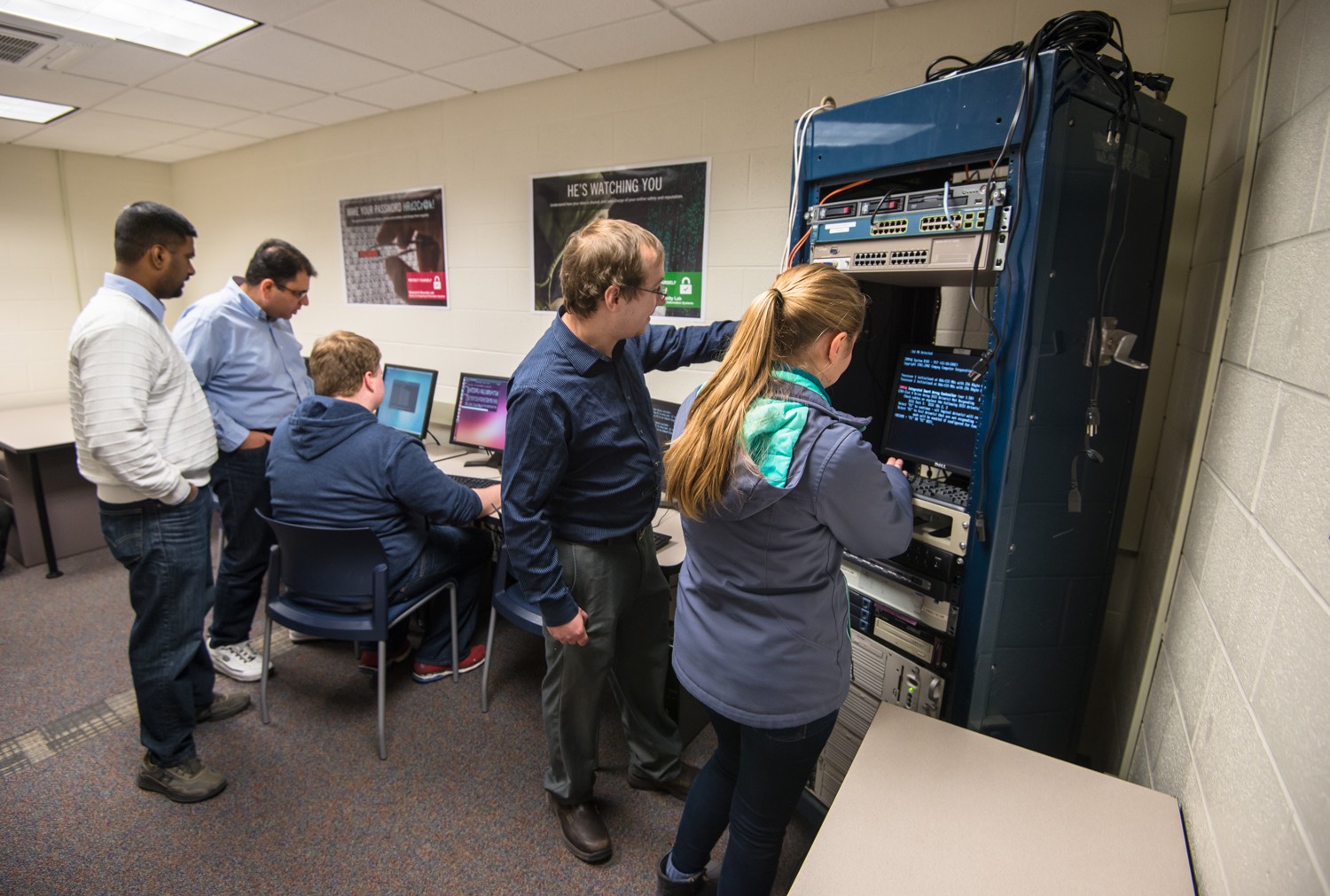 Faculty and students working on computer and server